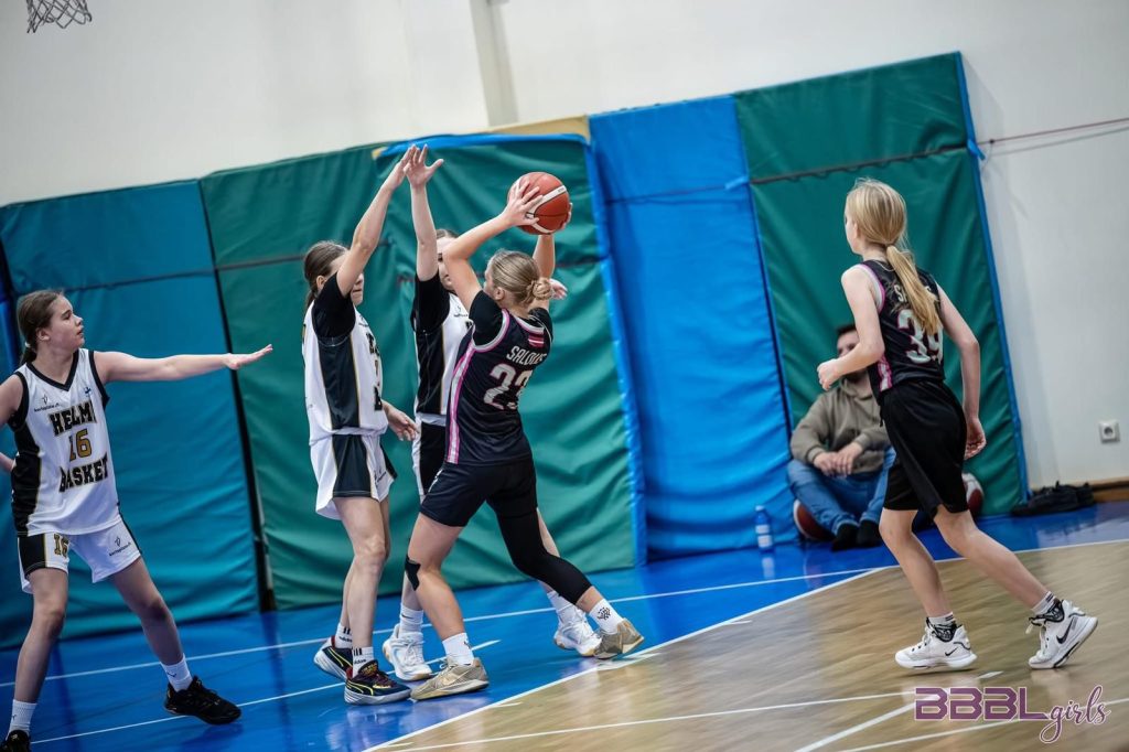 divas mūsu spēlētājas un trīs pretinieces. bumba mūsējai spēlētājai.