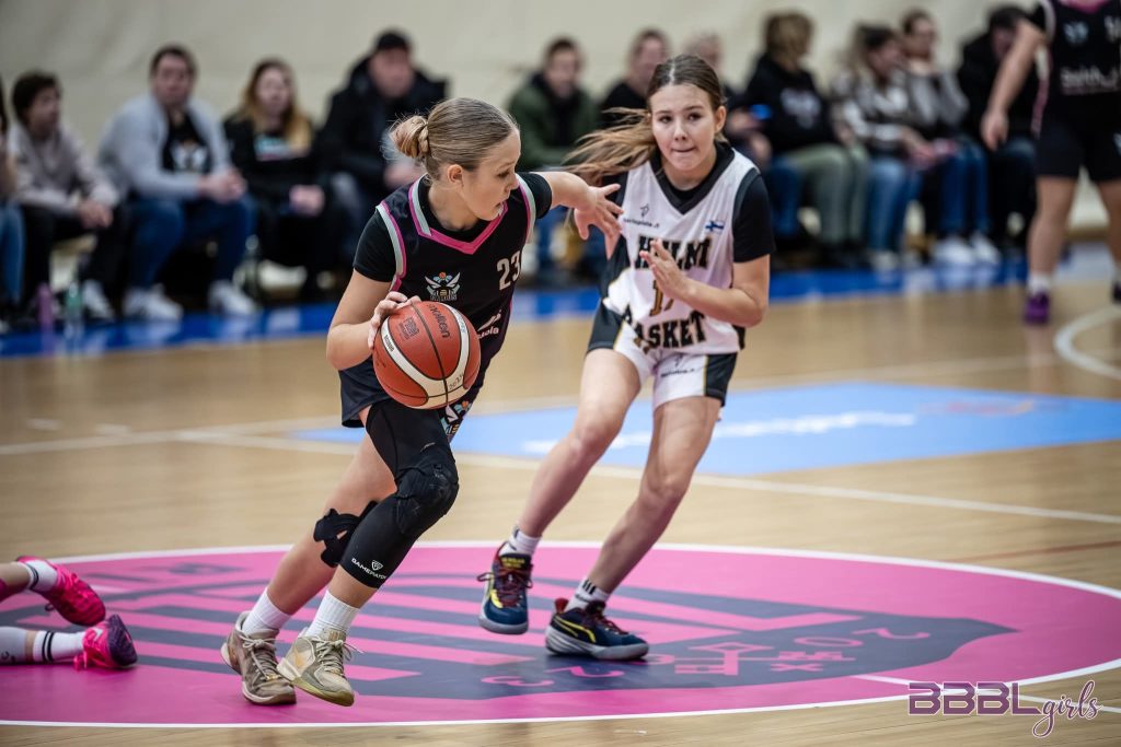 spēles moments. Mūsu basketboliste ar bumbu. blakus viena no pretiniecēm.