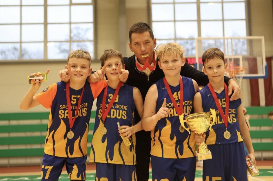 komandas kopbilde ar treneri. kaklā iegūtās medaļas