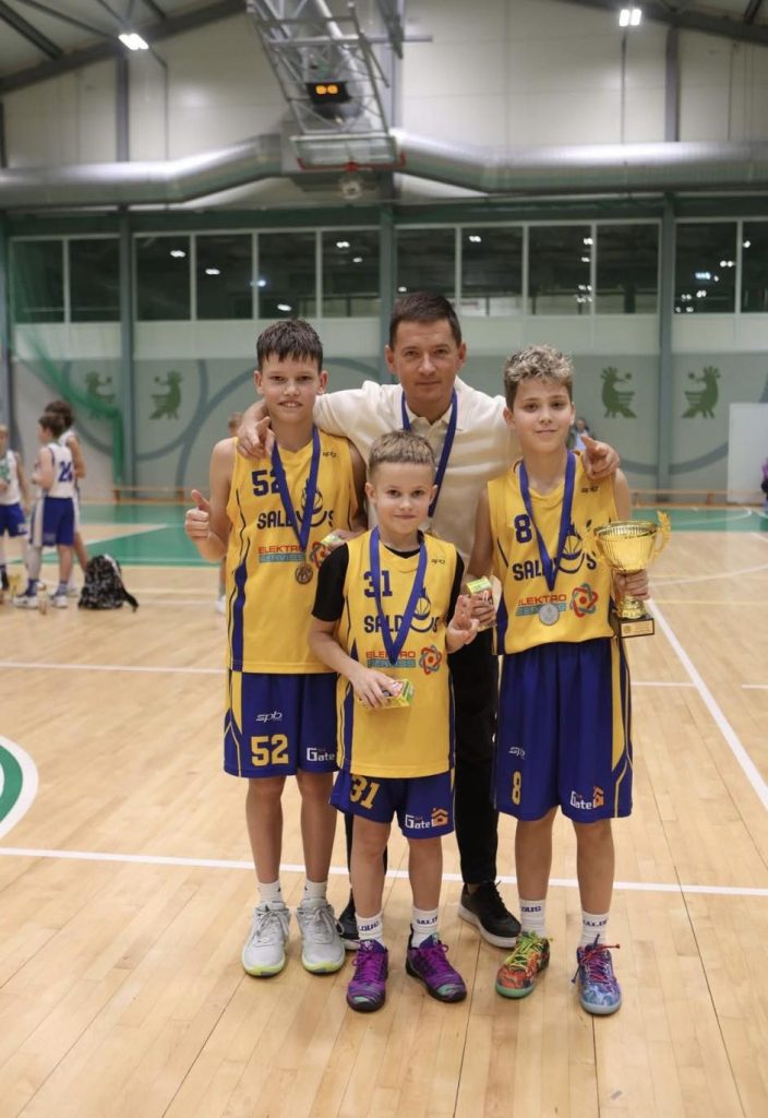 komandas kopbilde ar treneri. kaklā iegūtās medaļas