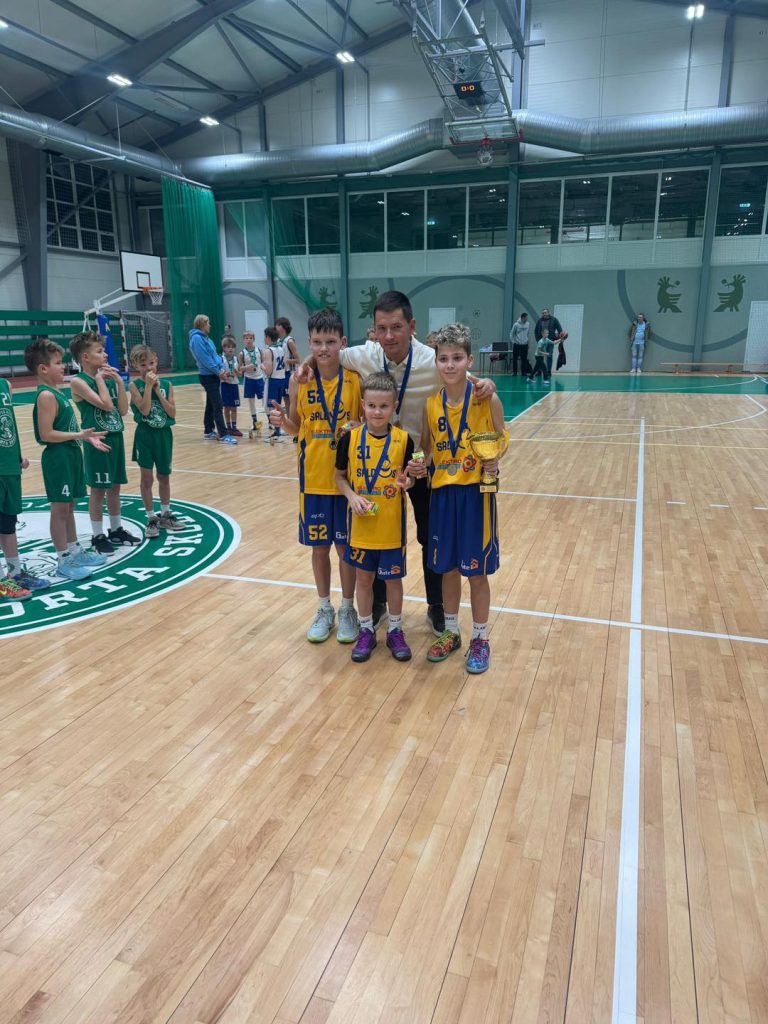 komandas kopbilde ar treneri. kaklā iegūtās medaļas