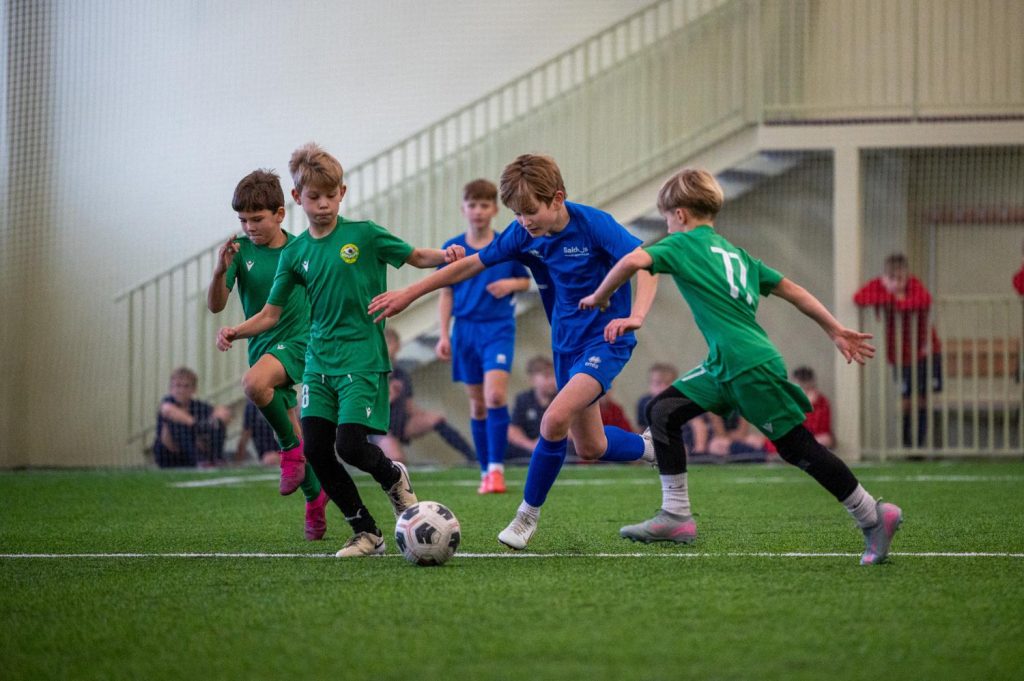 vairāki spēlētāji cīnās par bumbu