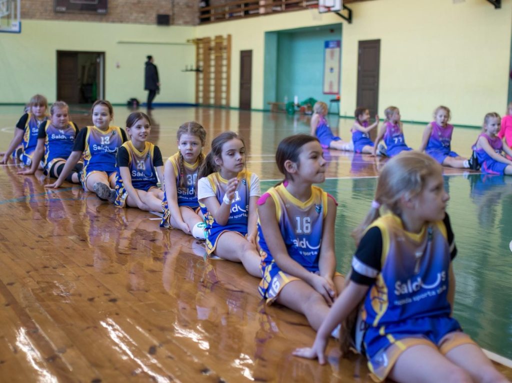 mūsu komandas basketbolistes apsēdušās uz zemes viena aiz otras