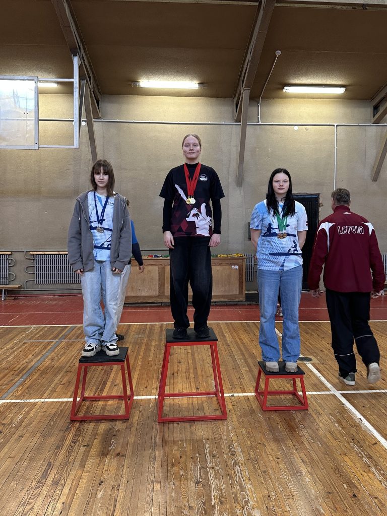 skats uz pjedestālu ar sacensību dalībniekiem