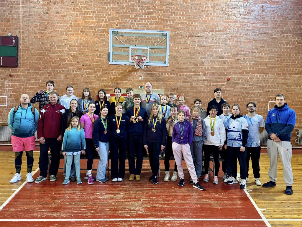 mūsu audzēkņu kopbilde ar treneriem pie basketbola groza