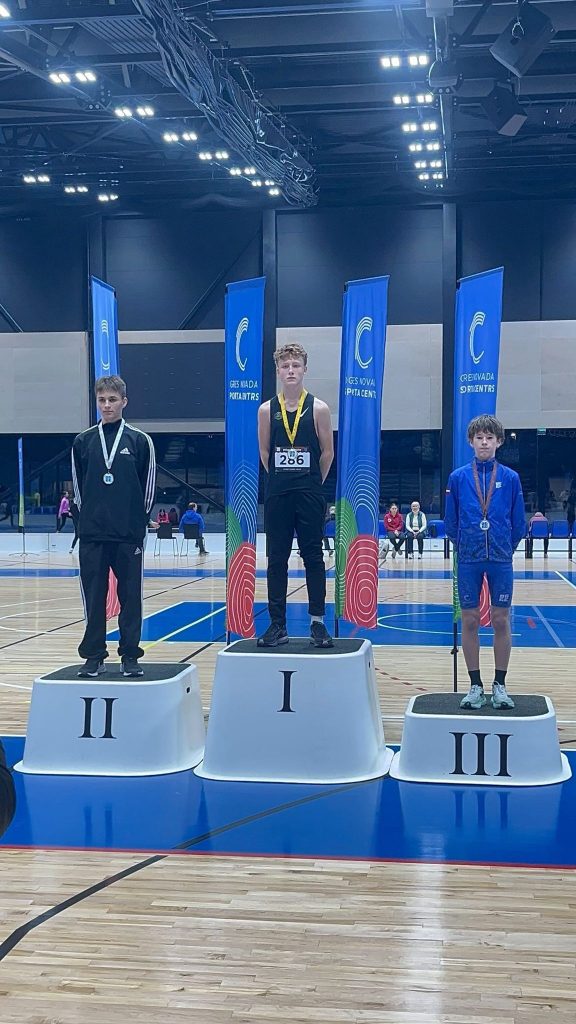 skats uz pjedestālu, uz pakāpieniem medaļnieki