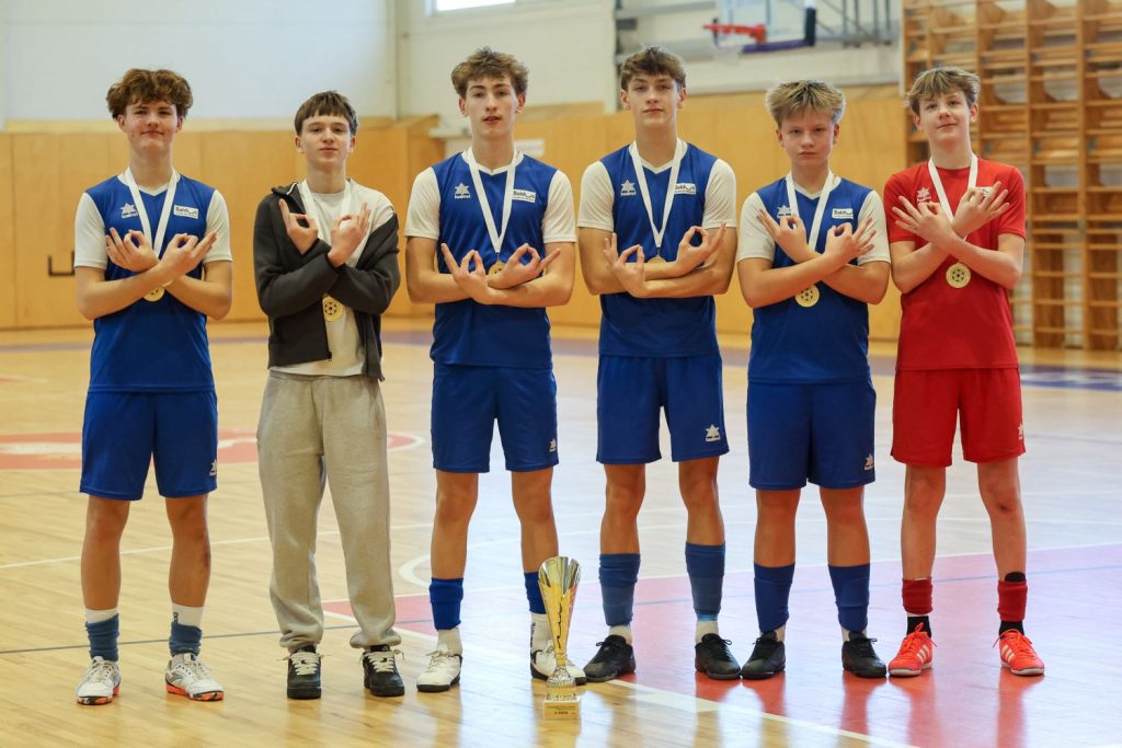 seši no futbolistiem pozē ar rokām rādot o burtiņus