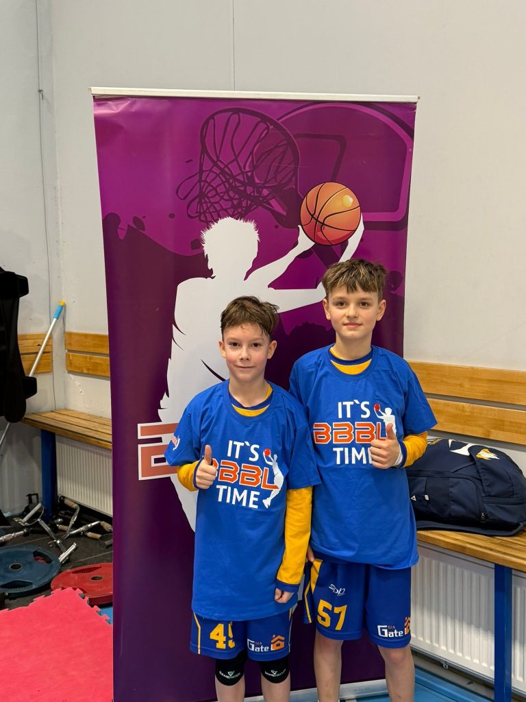 komandas divi labākie spēlētāji nofotogrāfējušies. zilos krekliņos. 