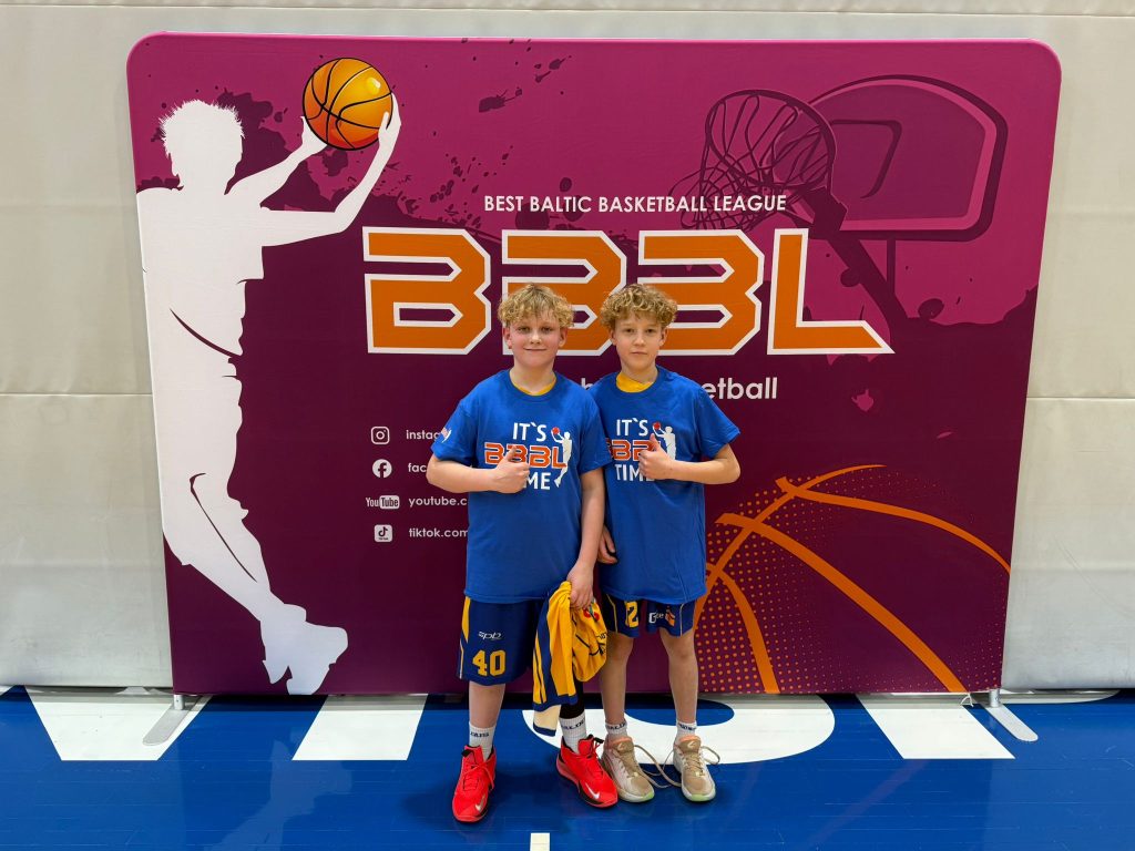 divi labākie spēlētāji. Nofotogrājējušies pie BBBL plakāta sienas.