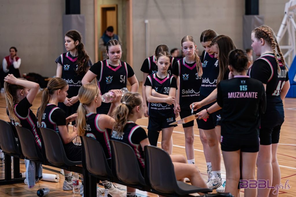 spēles starplaikā - trenere rāda sazīmētu shēmu uz planšetes.