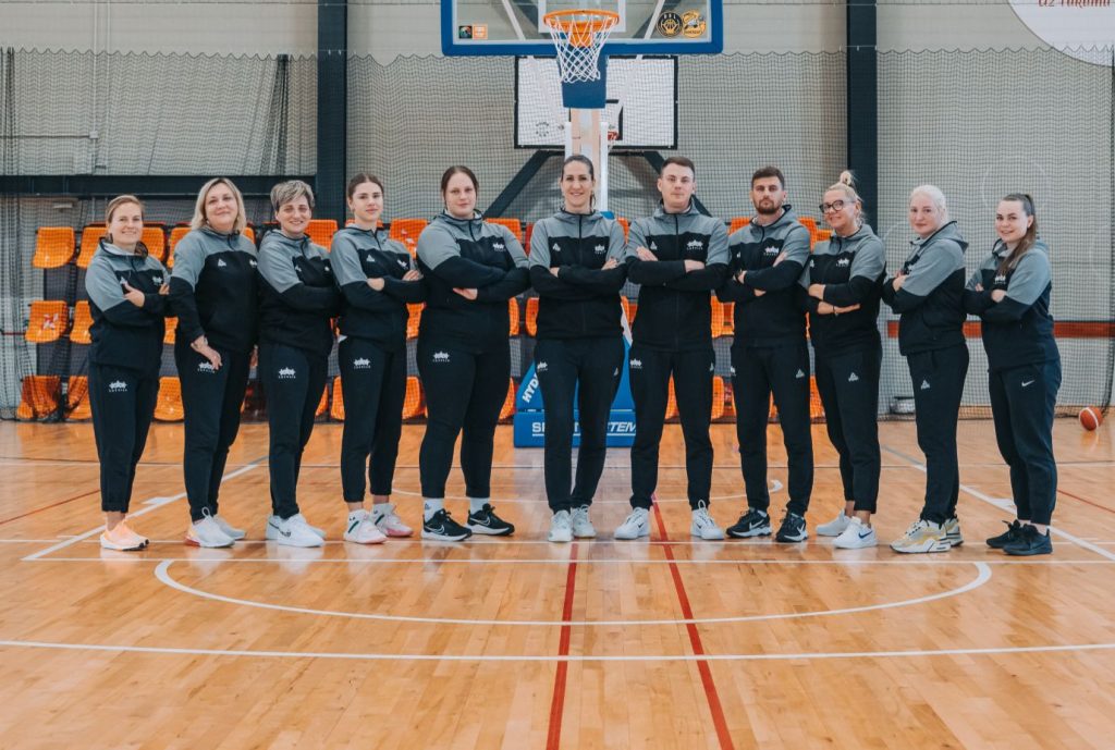 treneri sastājušies zem basketbola groza. rokas salikuši krūšu rajonā