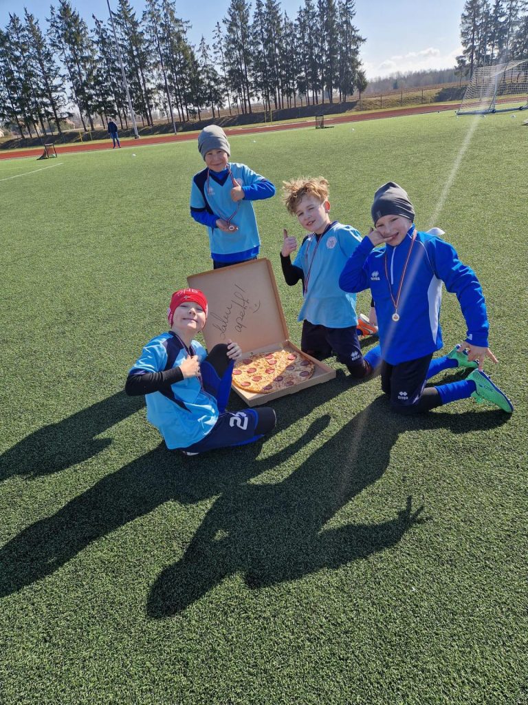 četri bērni pie atvērtas picas kastes