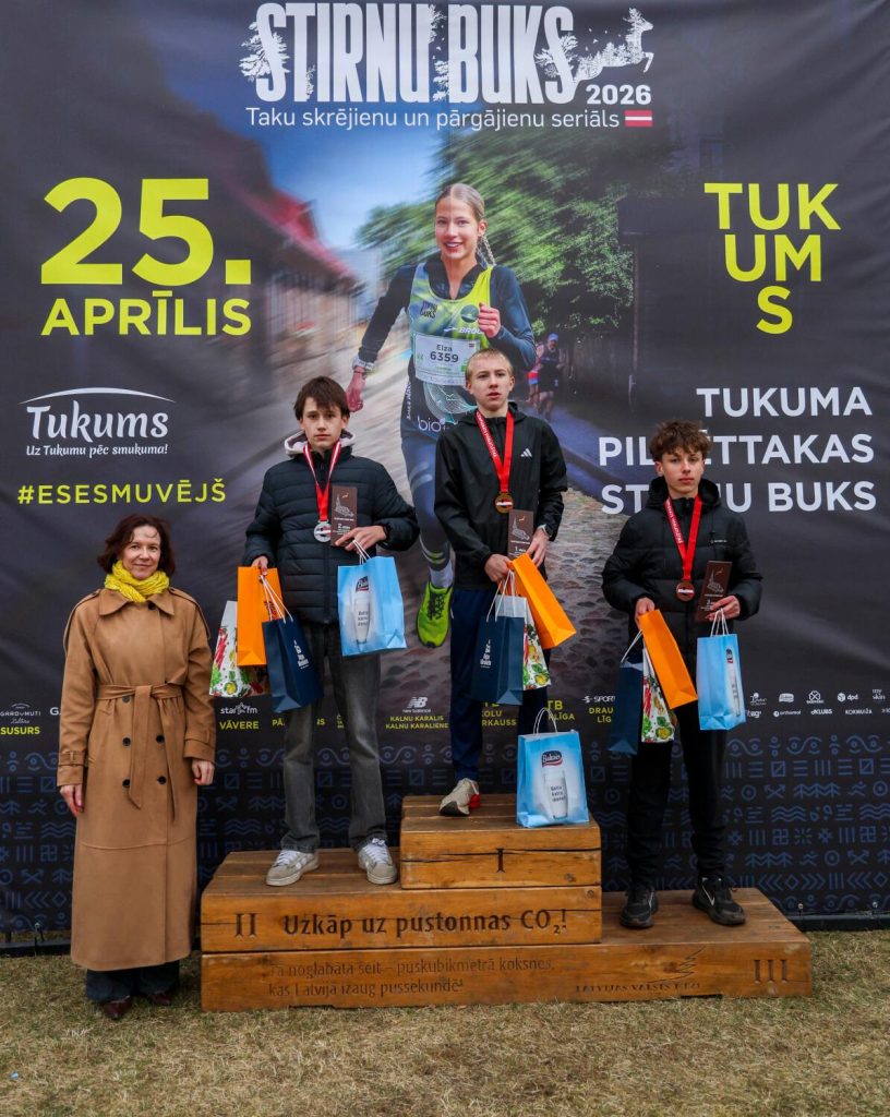 mūsu audzēknis uz pjedestāla trešās vietas, kaklā medaļa