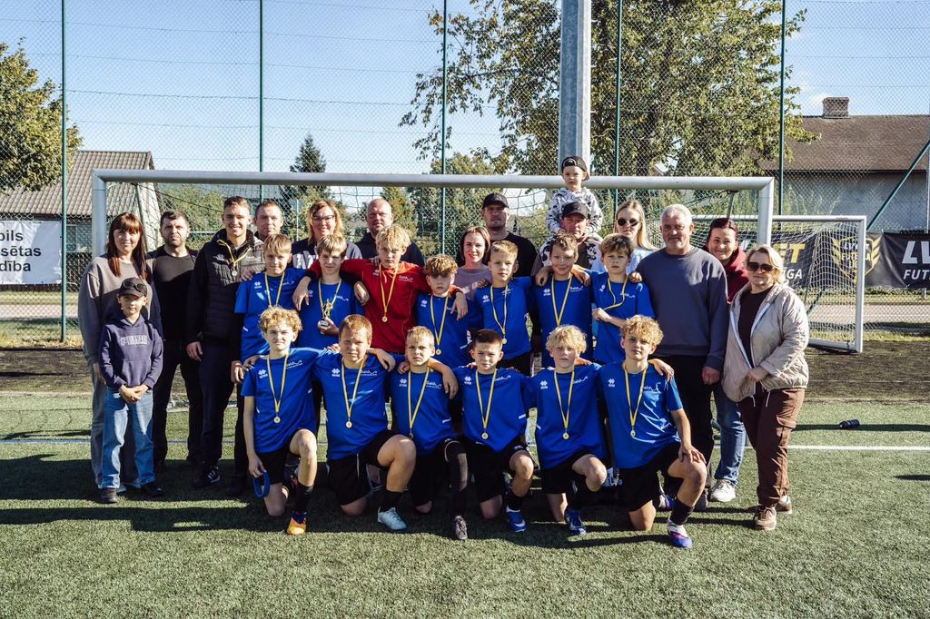 komanda kopā ar vecākiem pie vārtiem
